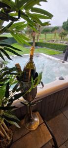 a bottle of wine sitting on a table next to a pool at LA VILLA DE SENY , complètement indépendant avec jardin ,Piscine privée, jacuzzi , petanque, fitness, billard,ping pong, 