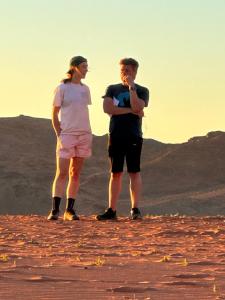 Ein Mann und eine Frau stehen in der Wüste in der Unterkunft bedouin future camp in Wadi Rum