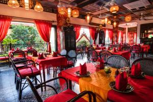 un restaurante con mesas rojas y sillas en una habitación en Khmer Surin Boutique Guesthouse, en Phnom Penh