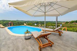 einen großen weißen Regenschirm und zwei Stühle und einen Pool in der Unterkunft StellaLuca Resort in Jalžabet