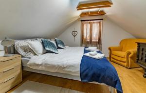 ein Schlafzimmer mit einem Bett und einem gelben Stuhl in der Unterkunft StellaLuca Resort in Jalžabet