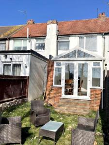 a house with a conservatory with chairs and a table at Elegant London home with Free 5G Wi-Fi, Garden, Workspace, Free Parking, Full Kitchen in Welling
