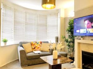 salon z kanapą i telewizorem w obiekcie Elegant London home with Free 5G Wi-Fi, Garden, Workspace, Free Parking, Full Kitchen w mieście Welling
