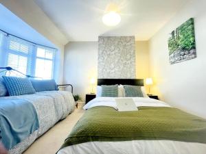 um quarto com 2 camas e uma grande janela em Elegant London home with Free 5G Wi-Fi, Garden, Workspace, Free Parking, Full Kitchen em Welling