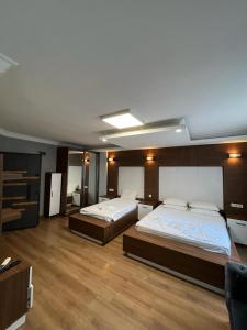 Habitación grande con 2 camas y suelo de madera. en family apart hotel, en Estambul