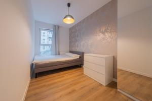 a small bedroom with a bed and a window at Baildona Inn in Katowice