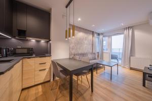 a kitchen and dining room with a table and a dining room at Baildona Inn in Katowice