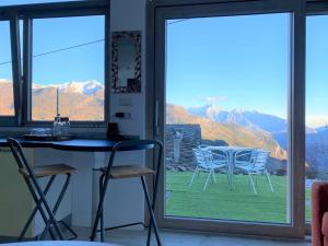 uma cozinha com uma mesa e cadeiras em frente a uma janela em B&B Tantané em Torgnon