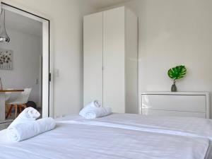 um quarto com uma cama branca e toalhas em Bilocale con terrazzi Via Antonio Riva 3 by LR em Lugano