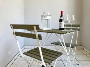uma mesa com uma garrafa de vinho e dois copos em Bilocale con terrazzi Via Antonio Riva 3 by LR em Lugano