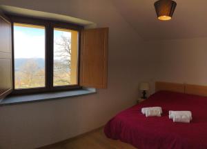 1 dormitorio con cama roja y ventana en Il Rifugio nel Comero, en Verghereto