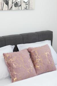 2 almohadas sentadas encima de una cama en Millennium Apartment en Bačka Palanka