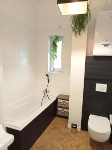 bagno con vasca, servizi igienici e finestra di The Manhattan Luxury suite a Jumet