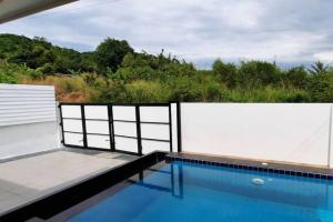 a swimming pool with a white fence around it at Pool Villa Sattahip White House in Sattahip