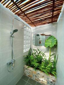 a bathroom with a shower and plants in it at Bến Đò Xưa Homestay & Coffee in Cái Răng