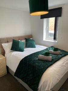 a bedroom with a bed with green pillows on it at 1 Bed @ Factory Quater - Chard St in Nottingham