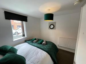 a bedroom with a bed and a clock on the wall at 1 Bed @ Factory Quater - Chard St in Nottingham