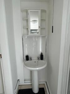 een badkamer met een witte wastafel en een spiegel bij 1 Bed @ Factory Quater - Chard St in Nottingham