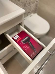 a book on a drawer in a bathroom with a toilet at Apartmán Kristína in Štúrovo