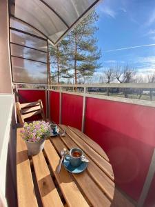 a wooden table with a cup of coffee on a balcony at Apartmán Kristína in Štúrovo