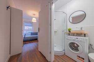 ein Badezimmer mit einer Waschmaschine und einem Spiegel in der Unterkunft TinyRooms in Kattowitz + 20 Fotos