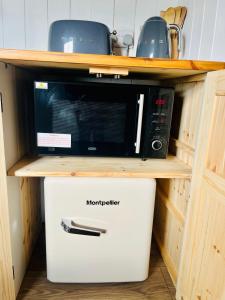 a microwave oven sitting on top of a cabinet at The Hut at High Street Farm in Sudbury