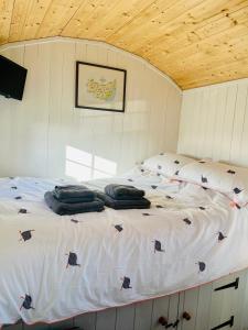 a large bed in a room with chickens on it at The Hut at High Street Farm in Sudbury