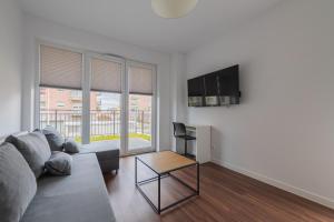 ein Wohnzimmer mit Sofa und Tisch in der Unterkunft TinyRooms in Kattowitz