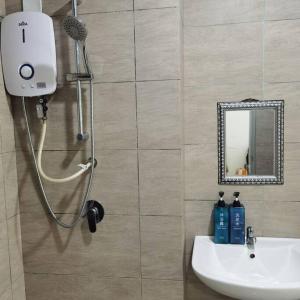 La salle de bains est pourvue d'une douche, d'un lavabo et d'un miroir. dans l'établissement Titiwangsa 6PX near monorail PWTC Infinity pool, à Kuala Lumpur