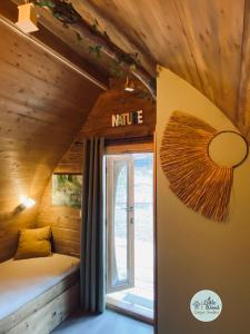 a small room with a bed and a window at Little Wood Lodges in Bailly-aux-Forges