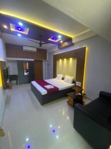 a hotel room with a bed and a couch at Redbell Suites Calicut in Kozhikode +13 photos