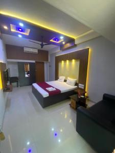 a hotel room with a bed and a couch at Redbell Suites Calicut in Kozhikode