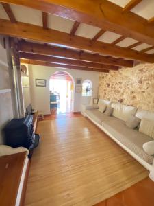 uma sala de estar com um sofá e uma parede de pedra em Santa Rosalia em Ciutadella
