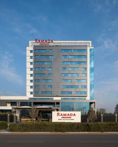 a tall building with a ryanada sign on it at Ramada by Wyndham Erbil Gulan Street in Erbil