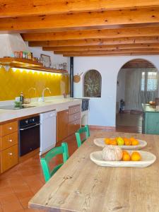 uma cozinha com uma mesa de madeira com frutas e legumes em Santa Rosalia em Ciutadella