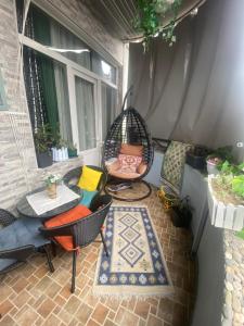 eine Terrasse mit einer Schaukel, einem Tisch und Stühlen in der Unterkunft Dea Apartments in Batumi