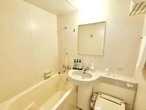 W łazience znajduje się umywalka, toaleta i wanna. w obiekcie Hotel Courtland w mieście Nagano