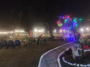 ラムナガルにあるAnugraha Homestayの夜の公園のテーブルに座る男