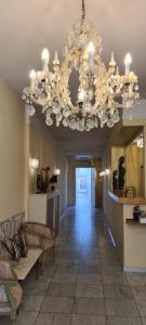 a living room with a chandelier and a hallway at Alliance Hotel Ieper Centrum in Ieper