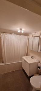 Un baño con una cortina de ducha blanca y un lavabo. en Alliance Hotel Ieper Centrum, en Ypres