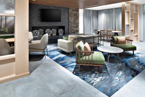 a lobby with a waiting area with chairs and tables at Fairfield by Marriott Inn & Suites Deerfield Beach Boca Raton in Deerfield Beach
