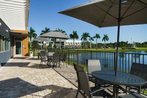 a patio with a table and chairs and an umbrella at Fairfield by Marriott Inn & Suites Deerfield Beach Boca Raton in Deerfield Beach