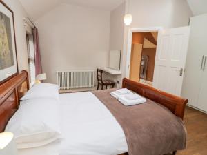 a bedroom with a bed with two towels on it at Dale Cottage in Llanrwst