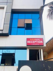 a building with a red sign on the side of it at Redbell Suites Calicut in Kozhikode