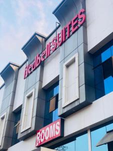 a building with a red sign on the side of it at Redbell Suites Calicut in Kozhikode