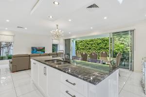 a kitchen with a sink and a living room at Swainson on Fawnbrake in Henley Beach South