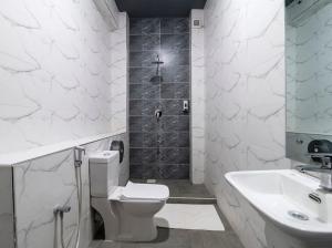 a white bathroom with a toilet and a sink at The Ivory Suites in Mombasa
