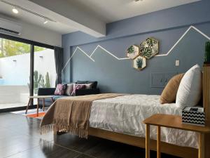 恆春的住宿－欖仁宿，一间卧室设有一张床和蓝色的墙壁
