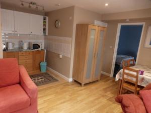 a living room with a couch and a kitchen at self-contained private apartment in Barnet