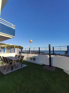 une terrasse avec une table et des chaises et l'océan dans l'établissement Casa Sete, à Alcanar